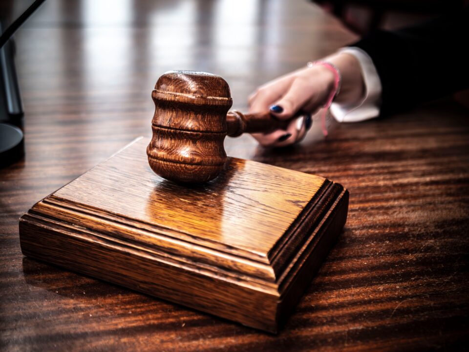 Image of a Judge Grabbing Hold of a Gavel to Call For Attention in The Courtroom