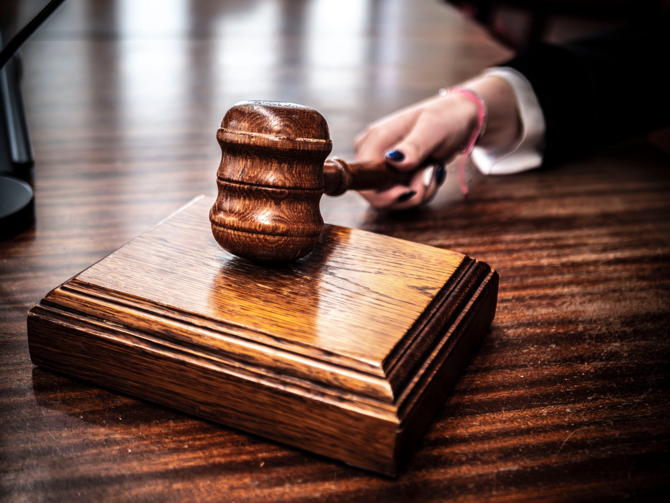 Image of a Judge Grabbing Hold of a Gavel to Call For Attention in The Courtroom